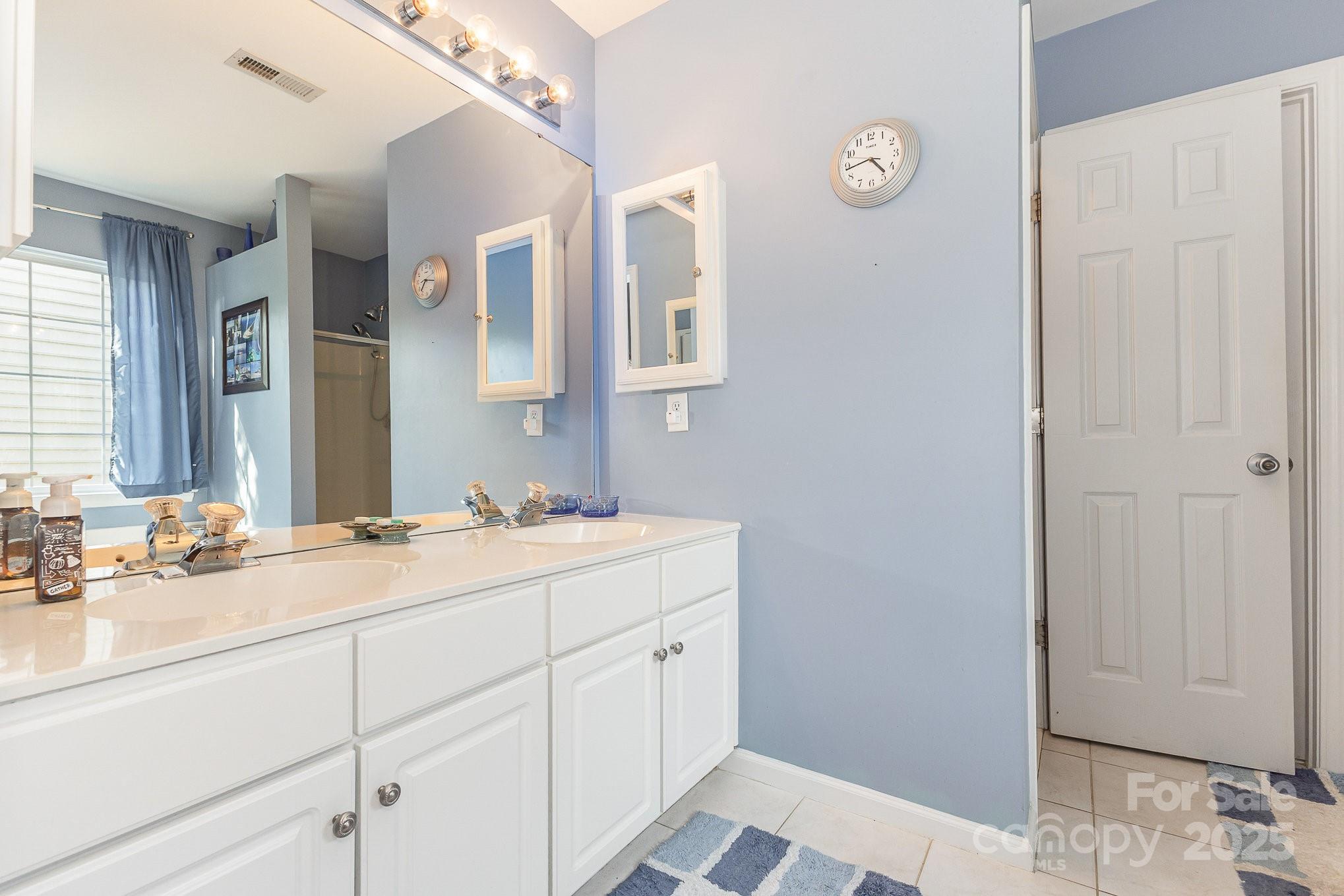 815 Clearbrook Road Matthews, NC 28105 - Photo 23 of 45 a en suite bathroom with a double vanity sink and a mirror