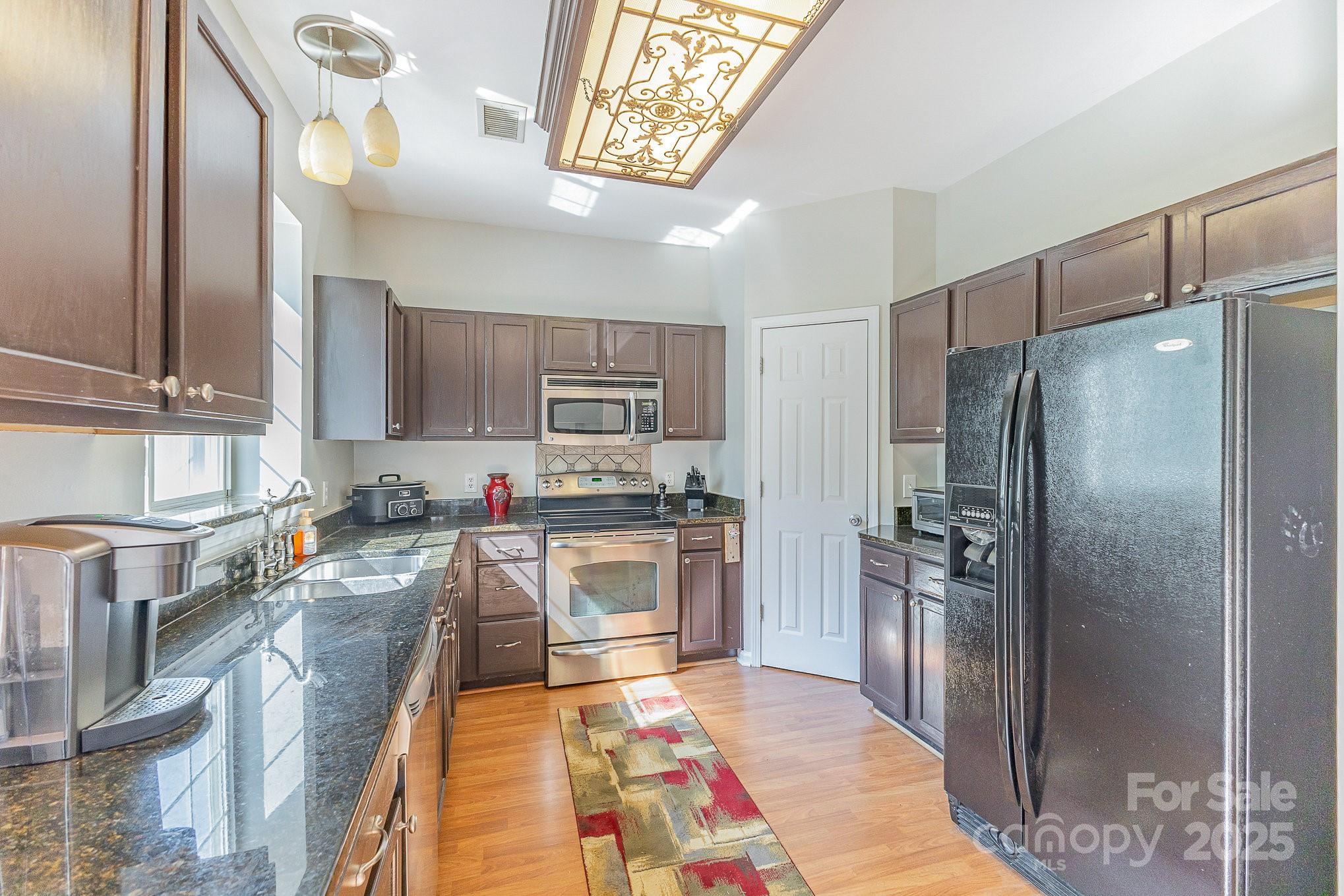 815 Clearbrook Road Matthews, NC 28105 - Photo 10 of 45 a kitchen with stainless steel appliances granite countertop a refrigerator a stove and a sink