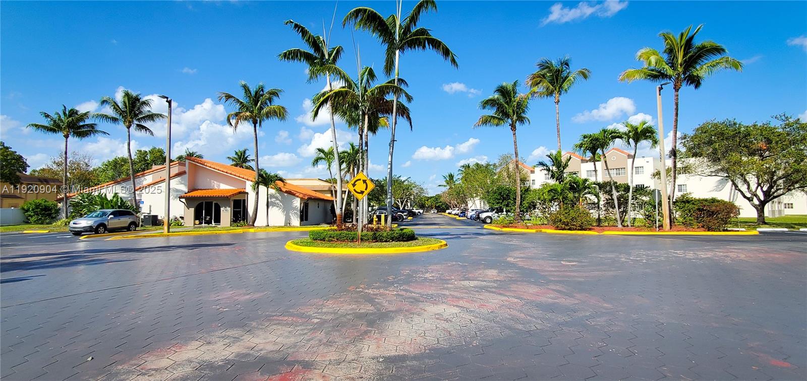 6065 Northwest 186th Street, Unit 106 Hialeah, FL 33015 - Photo 19 of 20 a view of a swimming pool with a lawn chairs under palm trees