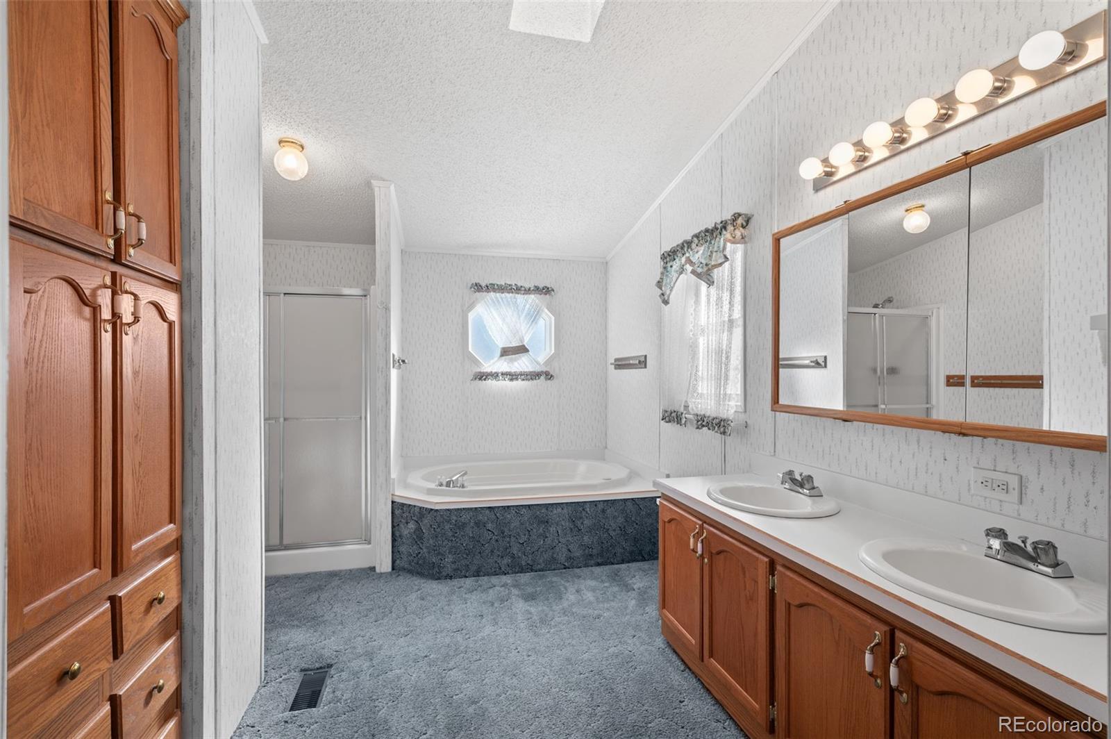 185 Elm Street Hudson, CO 80642 - Photo 25 of 43 a spacious bathroom with a tub sink and mirror