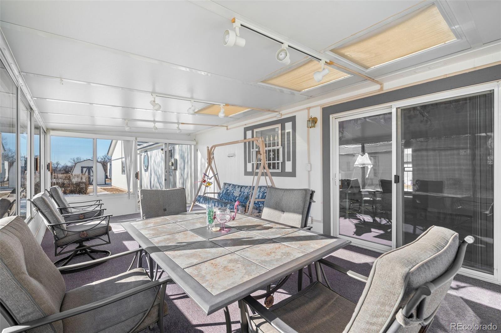 185 Elm Street Hudson, CO 80642 - Photo 31 of 43 a view of a dining room with furniture wooden floor and a chandelier