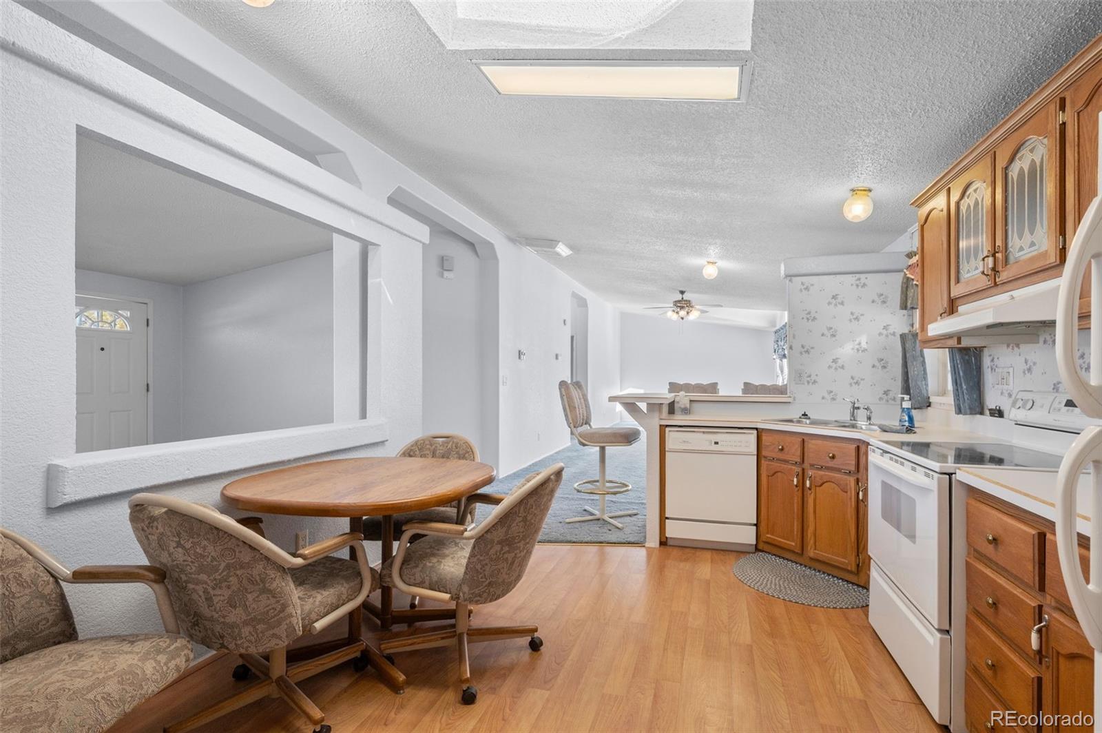185 Elm Street Hudson, CO 80642 - Photo 10 of 43 a kitchen with a table chairs sink and cabinets