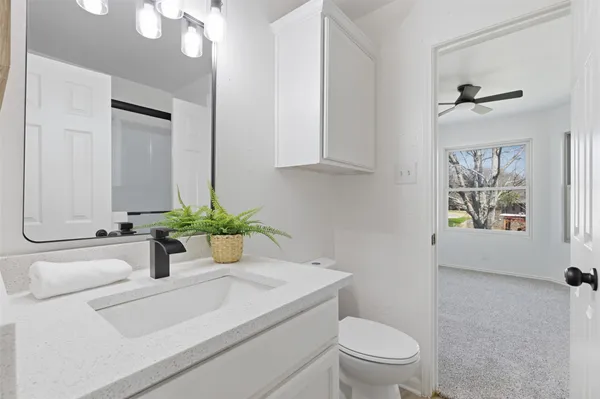 a bathroom with a sink a toilet and a mirror