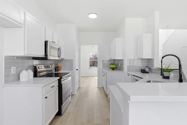 a kitchen with stainless steel appliances a sink stove and refrigerator
