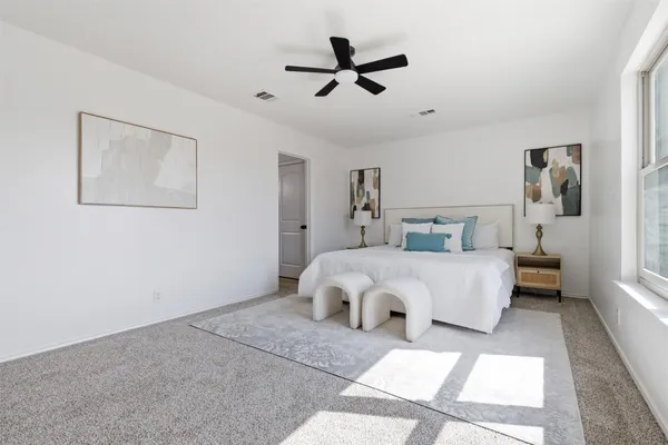 a bedroom with a large bed and a ceiling fan