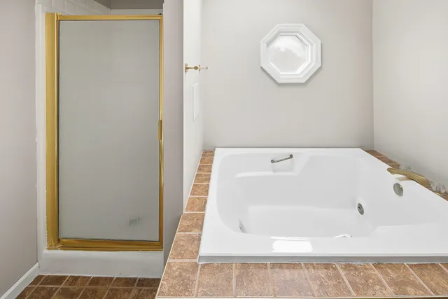 a bathroom with a double vanity sink mirror and bathtub