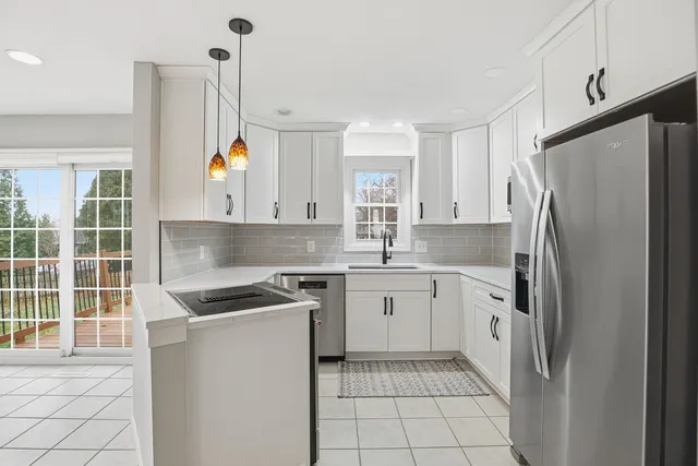 a kitchen with stainless steel appliances granite countertop a sink a stove and a refrigerator