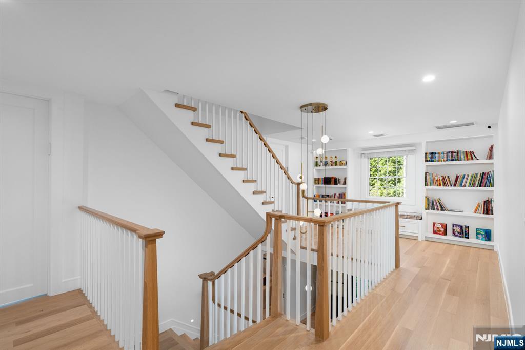306 Hutchinson Road Englewood, NJ 07631 - Photo 15 of 50 a view of a livingroom with furniture staircase kitchen view and hall with wooden floor