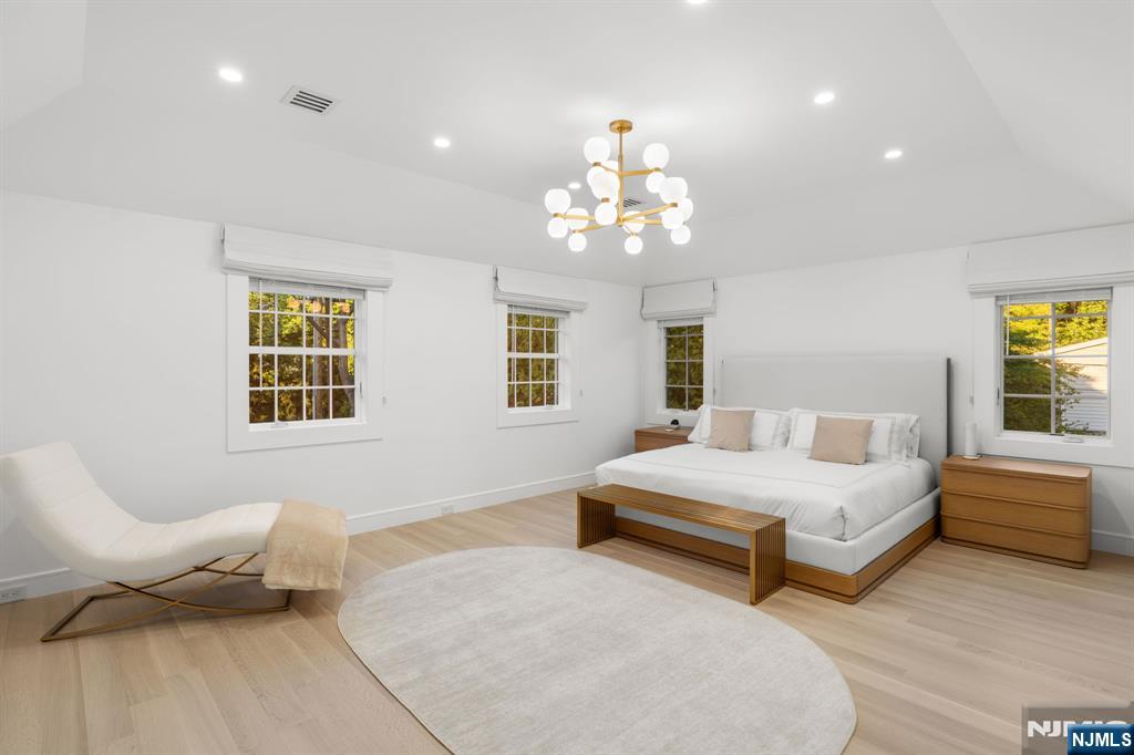 306 Hutchinson Road Englewood, NJ 07631 - Photo 17 of 50 a spacious bedroom with two beds and a chandelier
