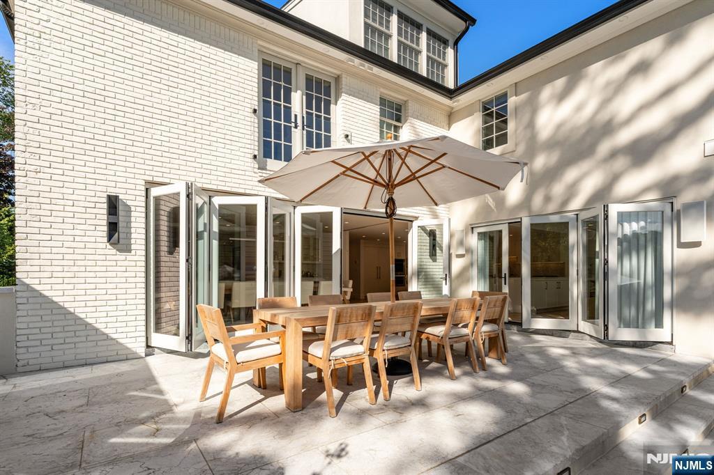 306 Hutchinson Road Englewood, NJ 07631 - Photo 32 of 50 a view of a patio with table and chairs and floor to ceiling window