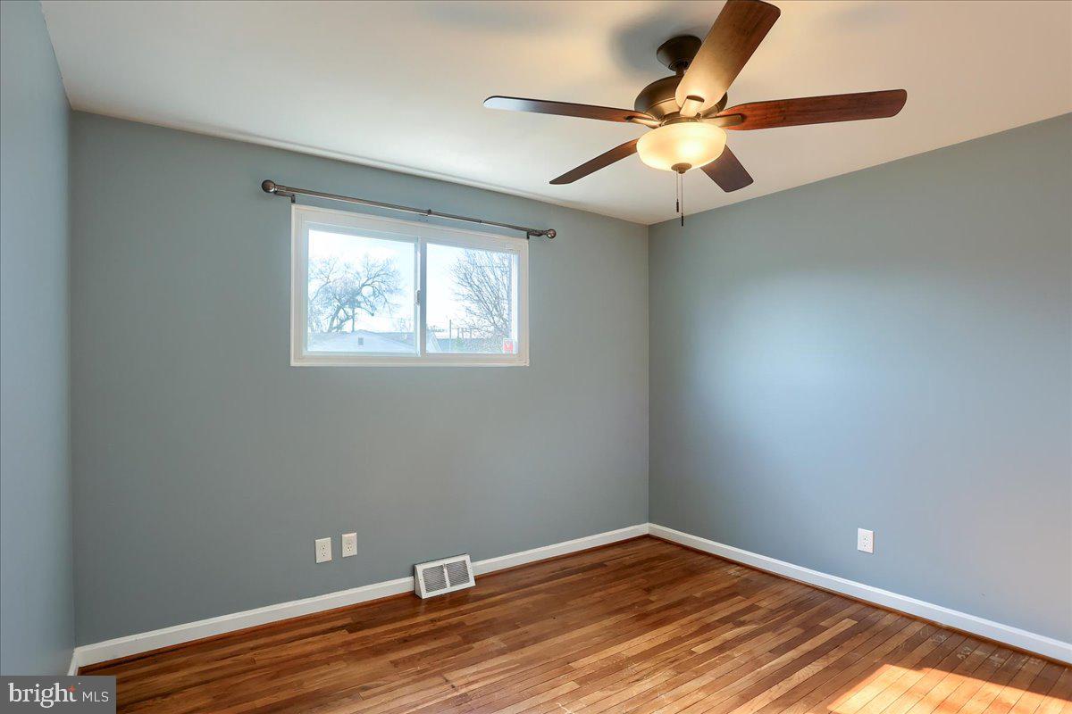 104 Cedarcliff Court Glen Burnie, MD 21060 - Photo 14 of 34 an empty room with wooden floor fan and windows