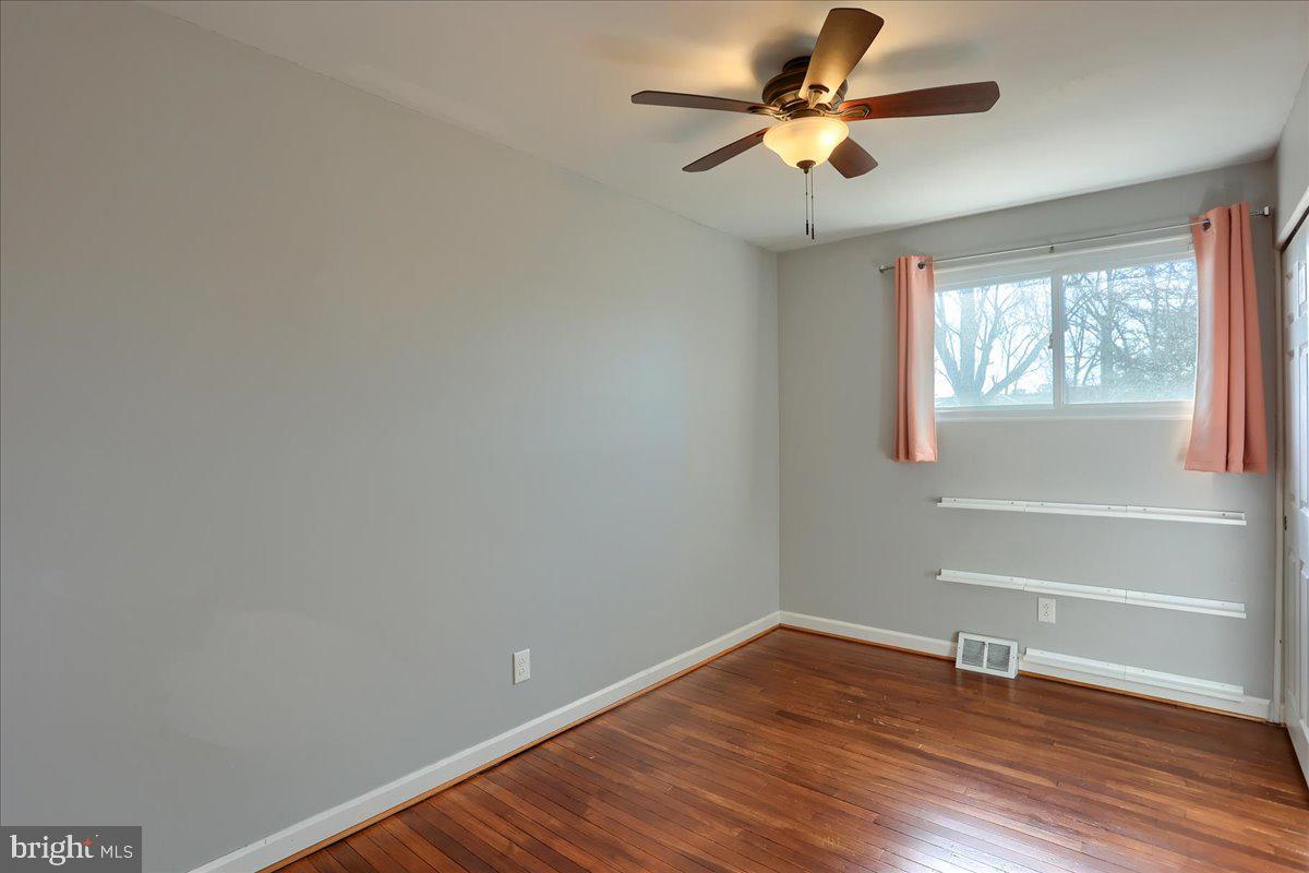 104 Cedarcliff Court Glen Burnie, MD 21060 - Photo 16 of 34 a view of empty room with wooden floor and fan