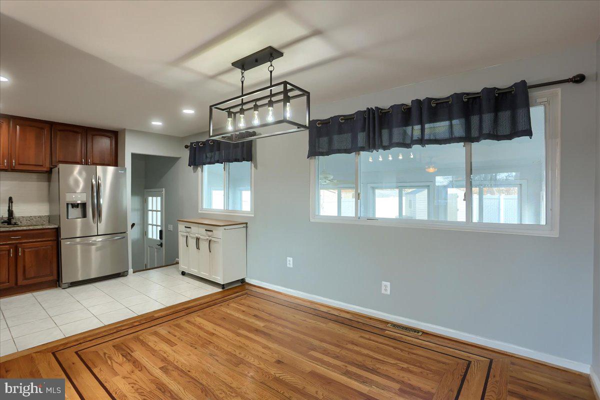 104 Cedarcliff Court Glen Burnie, MD 21060 - Photo 7 of 34 a kitchen with stainless steel appliances granite countertop a refrigerator a sink dishwasher a stove and white cabinets with wooden floor