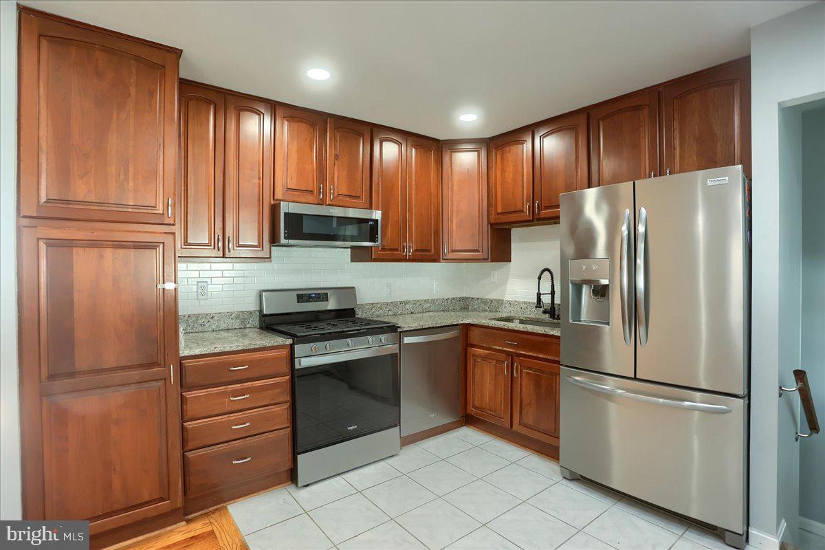104 Cedarcliff Court Glen Burnie, MD 21060 - Photo 9 of 34 a kitchen with granite countertop stainless steel appliances and refrigerator
