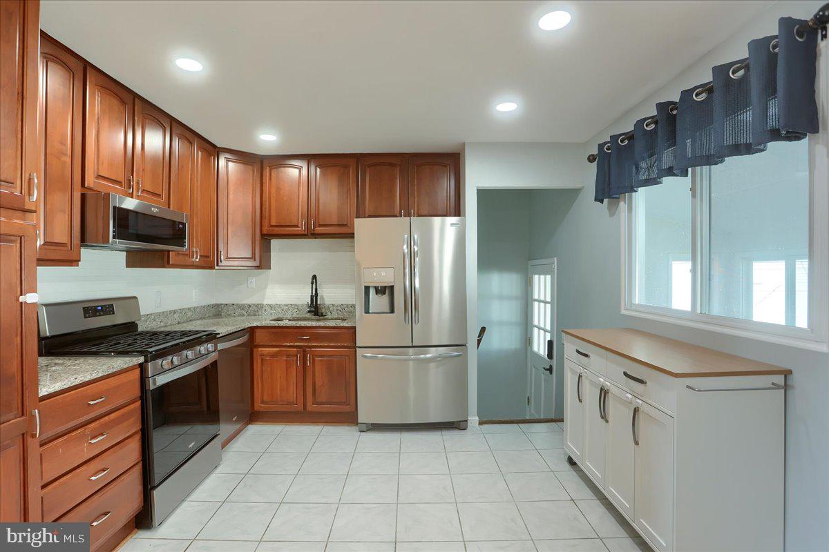 104 Cedarcliff Court Glen Burnie, MD 21060 - Photo 10 of 34 a kitchen with stainless steel appliances granite countertop a refrigerator and a stove top oven