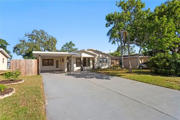 a front view of house with yard and trees in the background