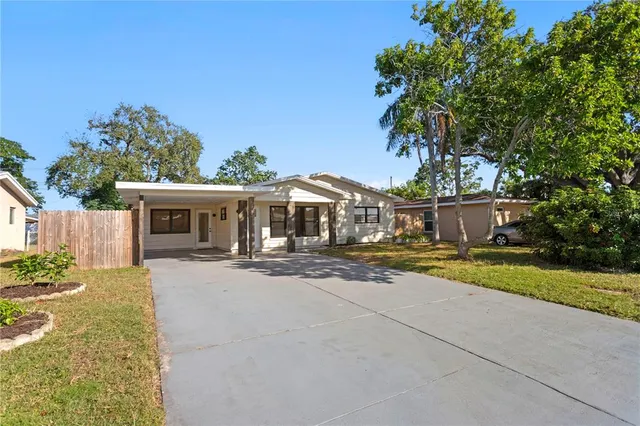 a front view of house with yard and trees in the background