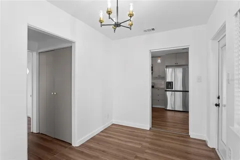 a view of a room with wooden floor and a ceiling fan