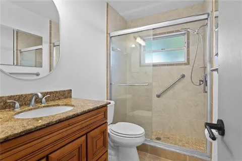 a bathroom with a granite countertop sink toilet and shower