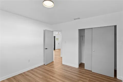 a view of an empty room with wooden floor