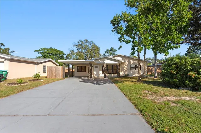 a view of a house with backyard and sitting area