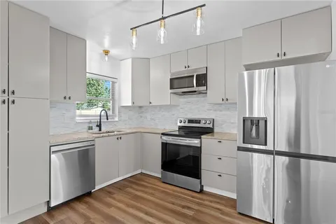 a kitchen with white cabinets and stainless steel appliances