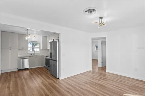 a kitchen with stainless steel appliances a refrigerator and wooden floor