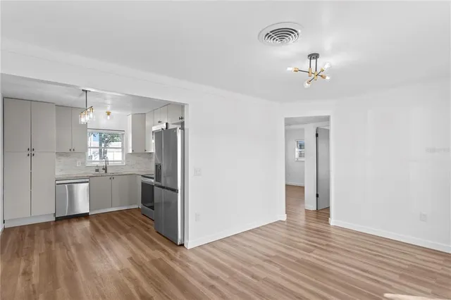 a kitchen with stainless steel appliances a refrigerator and wooden floor