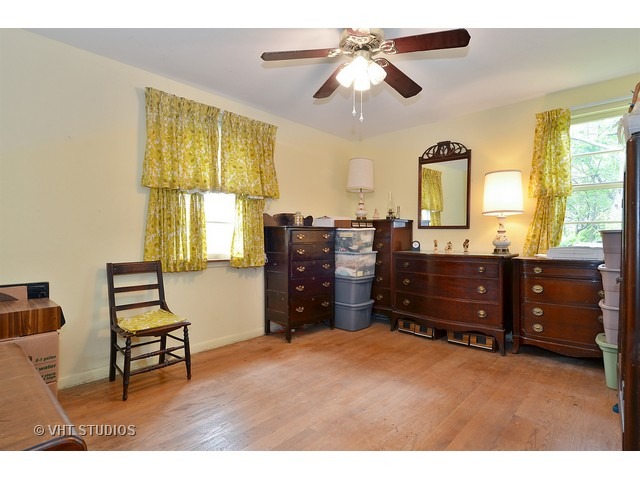 401 Warren Road Glenview, IL 60025 - Photo 6 of 10 a bedroom with a bed and a chandelier