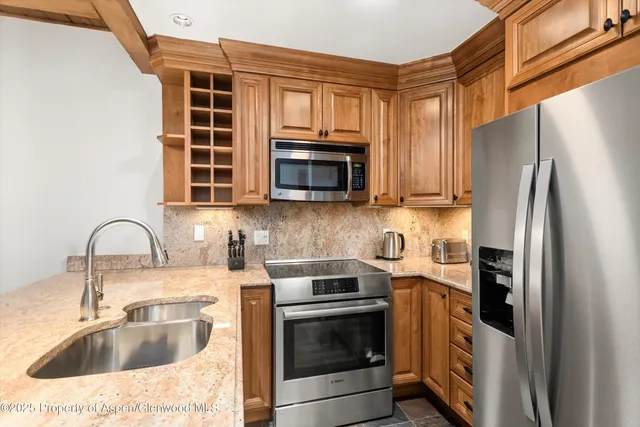 a kitchen with stainless steel appliances granite countertop a stove microwave and refrigerator