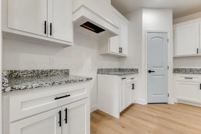 a kitchen with granite countertop cabinets stainless steel appliances and a counter space