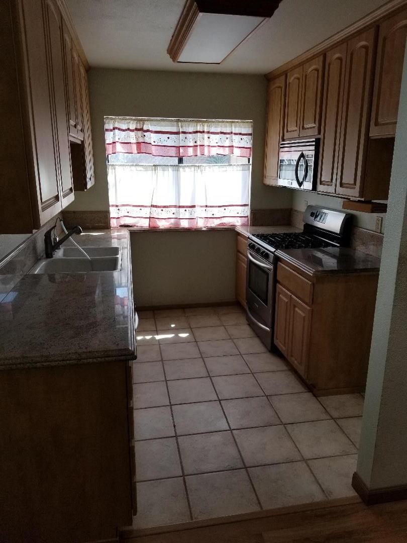 569 Powell Street Salinas, CA 93907 - Photo 7 of 14 a kitchen with granite countertop a stove a sink and a microwave
