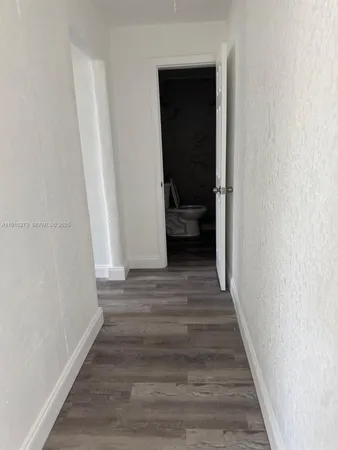 a view of a room with wooden floor