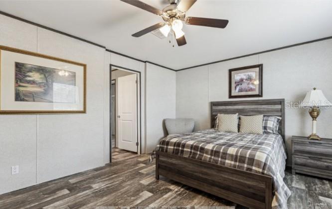 27760 Bermont Road Punta Gorda, FL 33982 - Photo 12 of 18 a bedroom with a bed and a chandelier