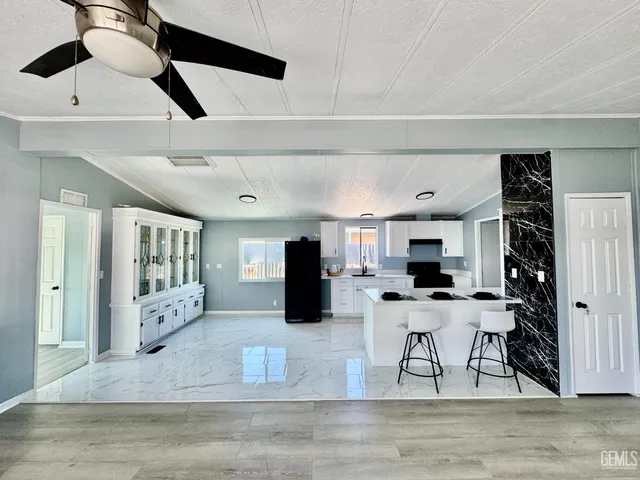 a kitchen with stainless steel appliances kitchen island granite countertop a refrigerator and microwave