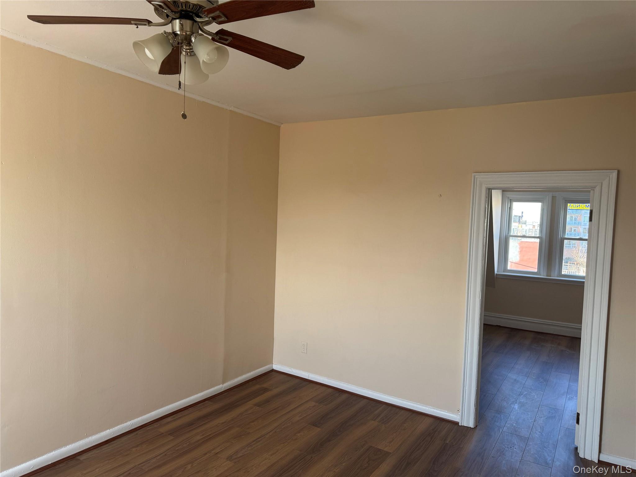776 Hewitt Place Bronx, NY 10455 - Photo 3 of 20 an empty room with wooden floor fan and windows