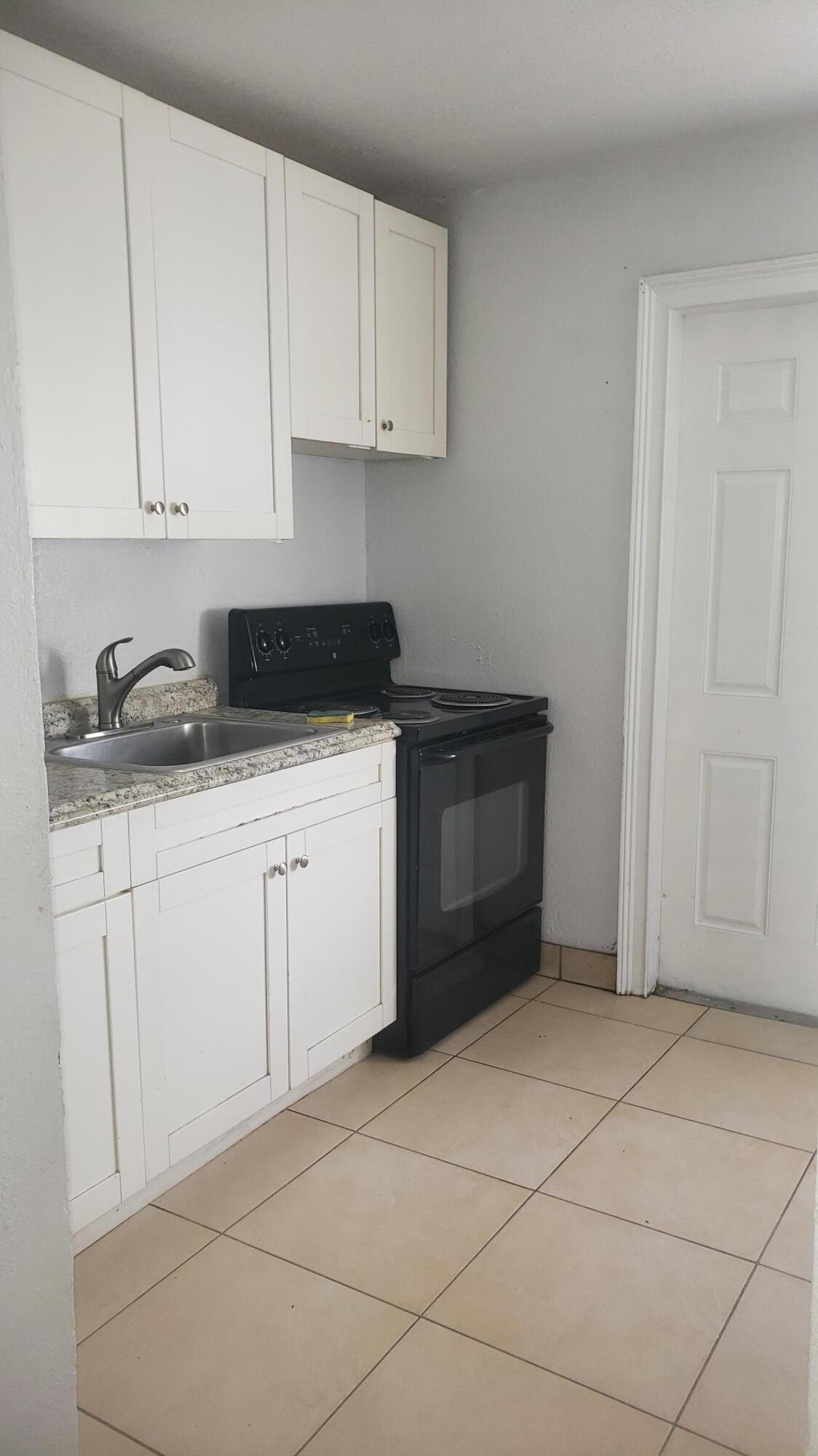 919 6th Street, Unit 15 West Palm Beach, FL 33401 - Photo 34 of 35 a kitchen with white cabinets and sink