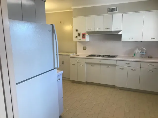 a kitchen with stainless steel appliances granite countertop white refrigerator stove and white cabinets