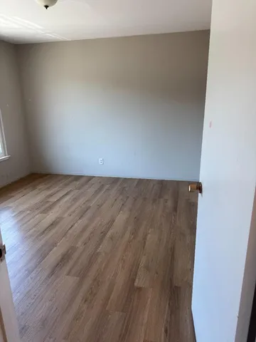 a view of a room with wooden floor
