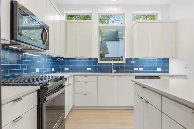 a kitchen with stainless steel appliances granite countertop a sink stove and cabinets