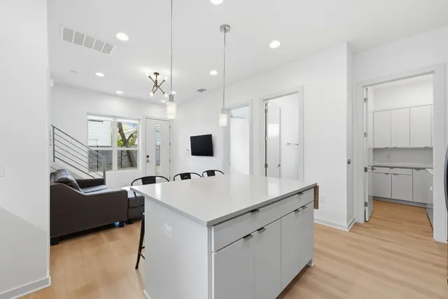 a large white kitchen with a sink a stove and a refrigerator