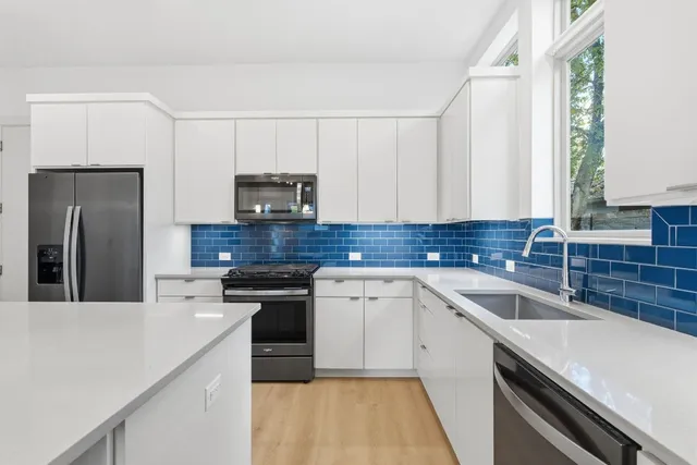 a kitchen with a sink cabinets and stainless steel appliances