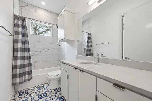 a bathroom with a sink a toilet a shower and a mirror