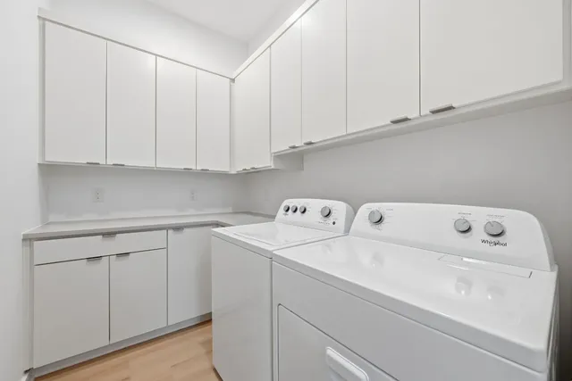 a utility room with dryer and cabinets