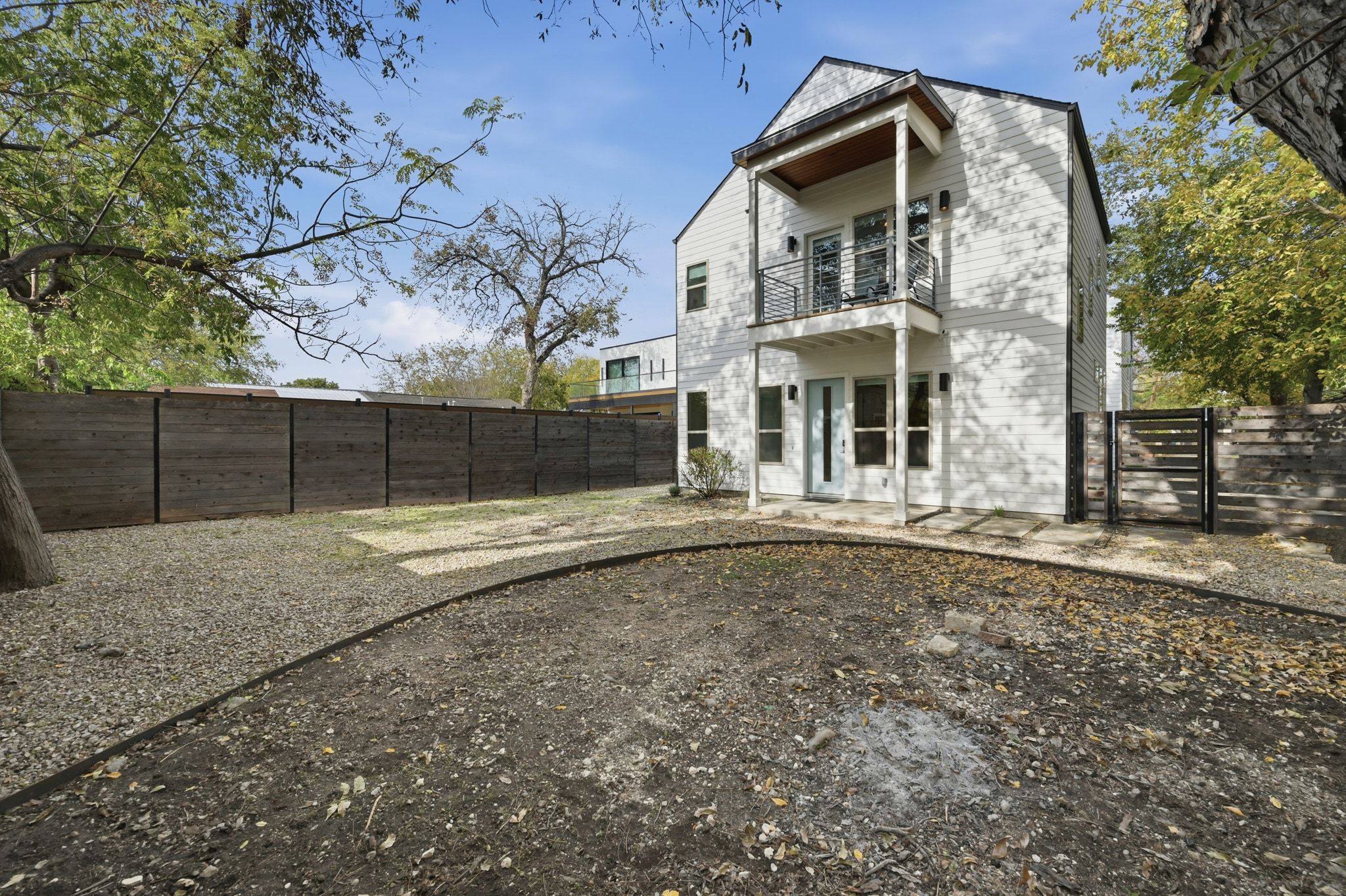 2811 Garwood Street, Unit B Austin, TX 78702 - Photo 5 of 25 a view of a white house with large trees and wooden fence
