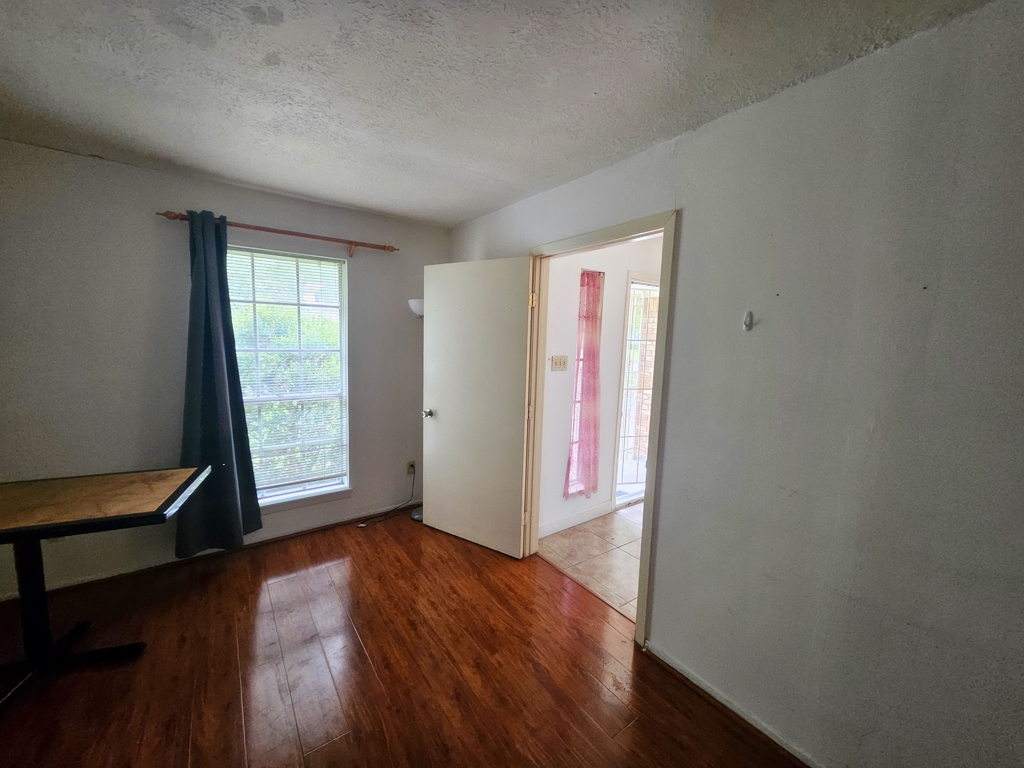 9318 Neff Street Houston, TX 77036 - Photo 10 of 10 an empty room with wooden floor and windows