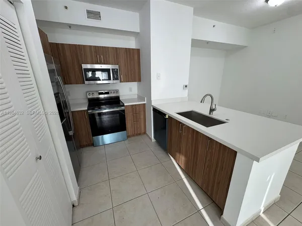 a kitchen with granite countertop a sink and stainless steel appliances