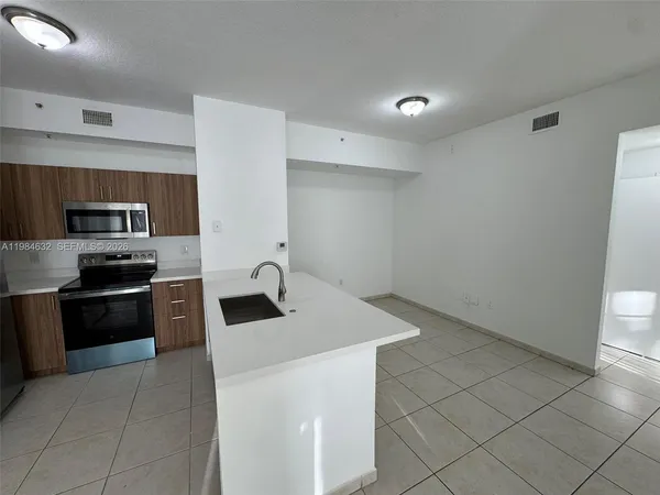 a kitchen with stainless steel appliances a sink stove and refrigerator