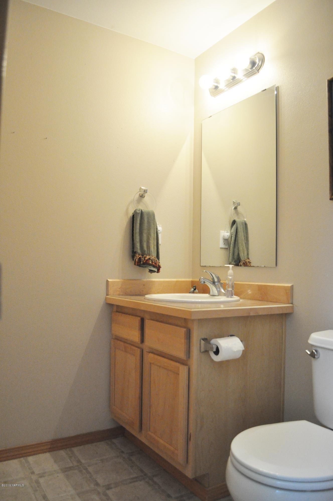 5011 Gamache Road Moxee, WA 98936 - Photo 12 of 26 a bathroom with a granite countertop toilet sink and mirror