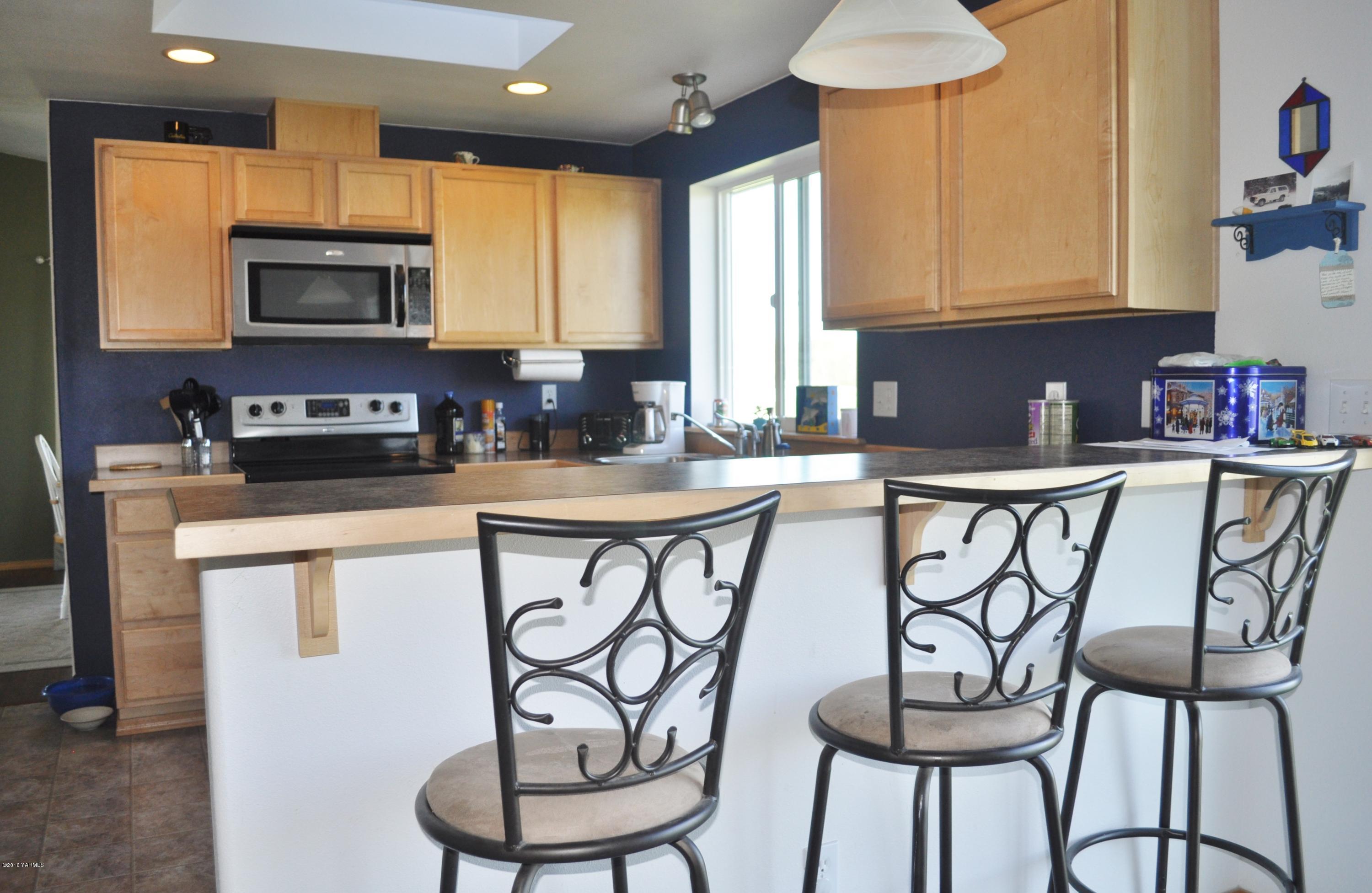 5011 Gamache Road Moxee, WA 98936 - Photo 6 of 26 a kitchen with stainless steel appliances a sink a stove a table and chairs